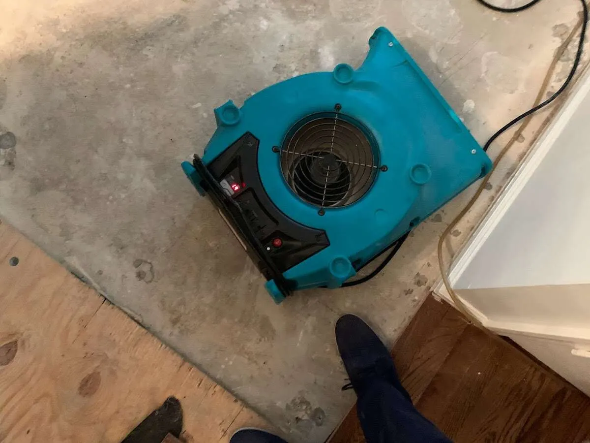 Air mover drying subfloor during Commercial Water Damage Restoration in Gantt